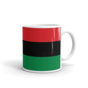 May include: A white ceramic mug with a red, black, and green flag design. The flag has three horizontal stripes: red, black, and green.