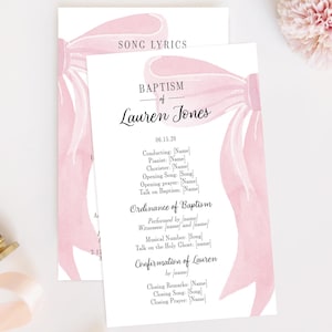 May include: Two white cards with pink watercolor bow illustrations. The cards read "SONG LYRICS" and "BAPTISM of Lauren Jones" with event details. A wooden stamp and a pink ribbon are on the left. A pink flower is on the top right.
