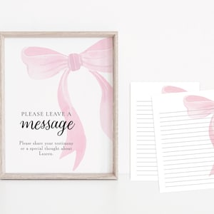 May include: A framed print with a light wood frame features a watercolor pink bow design. The text "PLEASE LEAVE A message" is displayed in black font. Two lined paper sheets with a pink bow design are also visible.