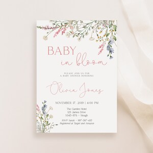 May include: A baby shower invitation with floral watercolor accents. The text reads "Baby in Bloom" and invites guests to celebrate Olivia Jones. The date and time are November 17, 2019, at 4:00 PM.