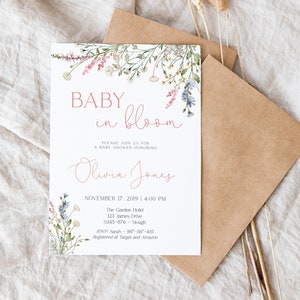 Pu&ograve; includere: Invito per baby shower con decorazioni floreali. L'invito recita "BABY in bloom" in un delicato carattere corsivo, con il nome "Olivia Jones" sotto. Sono inclusi anche data, ora, luogo e informazioni RSVP. L'invito &egrave; accompagnato da una busta marrone.