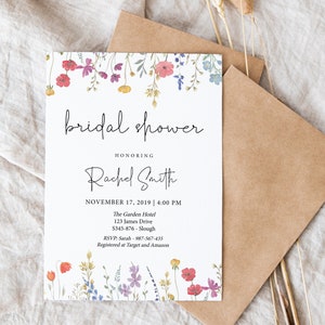 Puede incluir: Una invitaci&oacute;n de despedida de soltera blanca con un borde floral. La invitaci&oacute;n dice "bridal shower" en una fuente de escritura, seguida de "Honoring Rachel Smith". La fecha y la hora de la despedida de soltera se enumeran como "November 17, 2019 | 4:00 PM". La ubicaci&oacute;n se enumera como "The Garden Hotel, 123 James Drive, S345-876-Slough". La informaci&oacute;n de RSVP es "RSVP: Sarah - 987-567-435". La invitaci&oacute;n tambi&eacute;n indica que la pareja est&aacute; registrada en Target y Amazon.