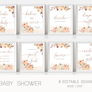 May include: Eight printable signs for a baby shower with an autumn theme. The signs feature watercolour illustrations of pumpkins, leaves, and flowers in shades of orange, pink, and white. The signs have text in a copper colour, including "books for baby", "babies are sweet", "drinks", "diaper raffle", "mimosa bar", "guest book", "favors", and "cards and gifts".