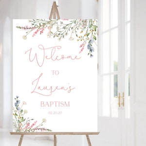May include: White welcome sign with pink floral border. The text reads "Welcome to Lauren's Baptism 02.20.20".