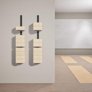 Puede incluir: Dos juegos de bloques de madera apilados uno encima del otro, montados en una pared con soportes de metal negro. Los bloques son de color marrón claro y tienen una veta de madera natural. Los bloques están en un estilo moderno y minimalista.