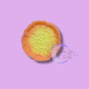 May include: A yellow and orange silicone mold shaped like a flower. The mold is designed to create resin crafts.