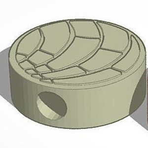 May include: A round, gray, ceramic bead with a raised, geometric design on the top. The bead has two holes on the side for threading.
