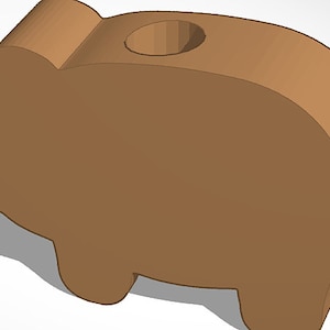 May include: A brown wooden piggy bank with a hole in the top for coins. The piggy bank is shaped like a pig and has a smooth, rounded surface.