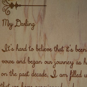 May include: A wooden sign with a handwritten message that reads "My Darling It's hard to believe that it's been 10 years since we said our vows and began our journey as husband and wife.  Looking back on the past decade, I am filled with gratitude for all that we have experienced and the life we have built together.  I love you more than words can say."
