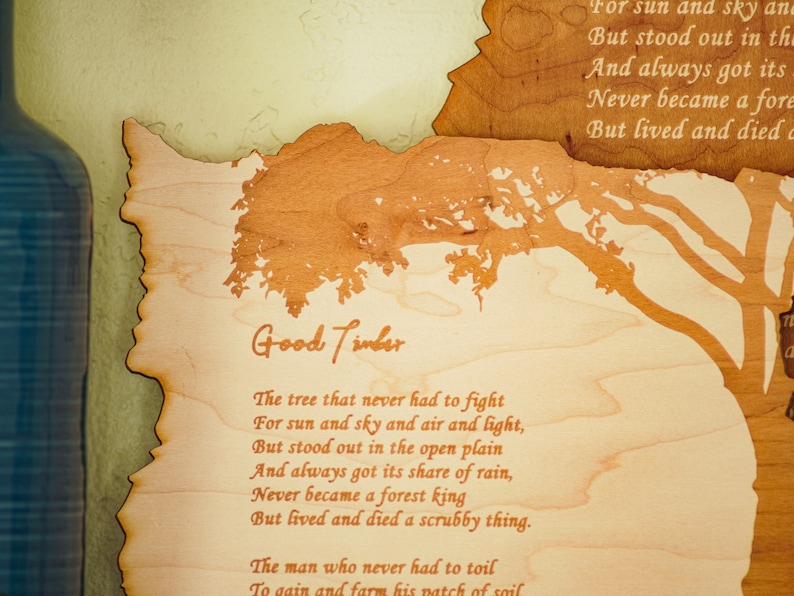 May include: Wooden wall art with the poem "Good Timber" etched into the wood. The artwork features a tree silhouette and a profile of a person. The poem is written in a serif font.