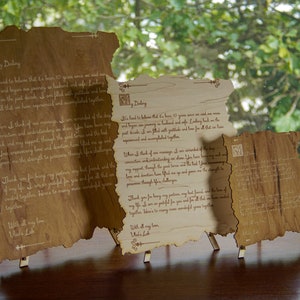 May include: Three wooden scrolls with a rustic, aged look, each with a handwritten message. The scrolls are displayed on small wooden stands. The text on the scrolls reads: "It's hard to believe that it's been 10 years since we said our vows and began our journey as husband and wife. Looking back on the past decade, I am filled with gratitude and love for all that we have experienced and accomplished together."