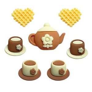 May include: A set of six brown and white ceramic teacups and teapot with flower designs. The set includes two heart-shaped waffle cookies.