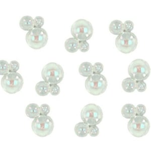 May include: Iridescent, clustered, round embellishments. Each cluster features a large central bead with two smaller beads attached. The beads have a pearlescent sheen, reflecting a spectrum of colors. These decorative elements are ideal for craft projects.