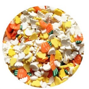 May include: A close-up of a variety of colorful sprinkles, including white, yellow, orange, and green. The sprinkles are shaped like carrots, bunnies, and other Easter-themed shapes.