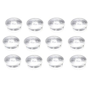 May include: Twelve small, silver-colored, button-shaped objects are arranged in a grid pattern against a white background. Each button has a flat, circular top and a slightly raised, rounded base.