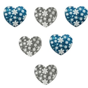 May include: Six heart-shaped ornaments with a snowflake pattern. Three ornaments are silver with white snowflakes and three ornaments are blue with white snowflakes.
