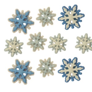 May include: Assortment of blue and white snowflake-shaped decorations. The snowflakes are made of a white material with a blue outline.