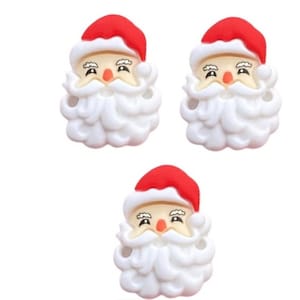 May include: Three white plastic Santa Claus ornaments with red hats and white beards. The ornaments have black eyes, a red nose, and a black smile.