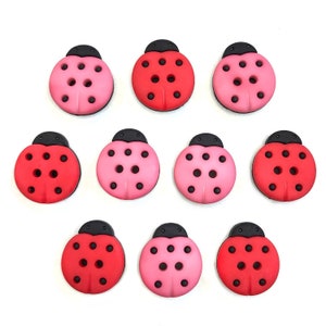 May include: Ten ladybug buttons in red and pink with black spots and heads.