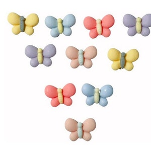 May include: Assortment of pastel-colored butterfly cake decorations. The butterflies are made of fondant and come in shades of pink, blue, yellow, and purple.