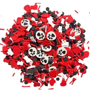 May include: A colorful mix of red hearts, black circles, white bones, and paw print shapes. This assortment of decorative sprinkles is perfect for baking or crafting projects. The sprinkles are a mix of shapes and sizes.