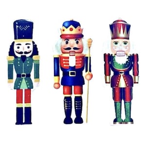 May include: Three colorful wooden nutcrackers in a row. The nutcrackers are dressed in various uniforms with hats, mustaches, and holding a staff. The nutcrackers are painted in shades of blue, red, green, and gold. The background is white.