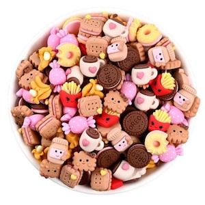 May include: A bowl filled with colorful, miniature food-themed charms. The charms are made of polymer clay and feature various designs, including donuts, coffee cups, french fries, and candy.