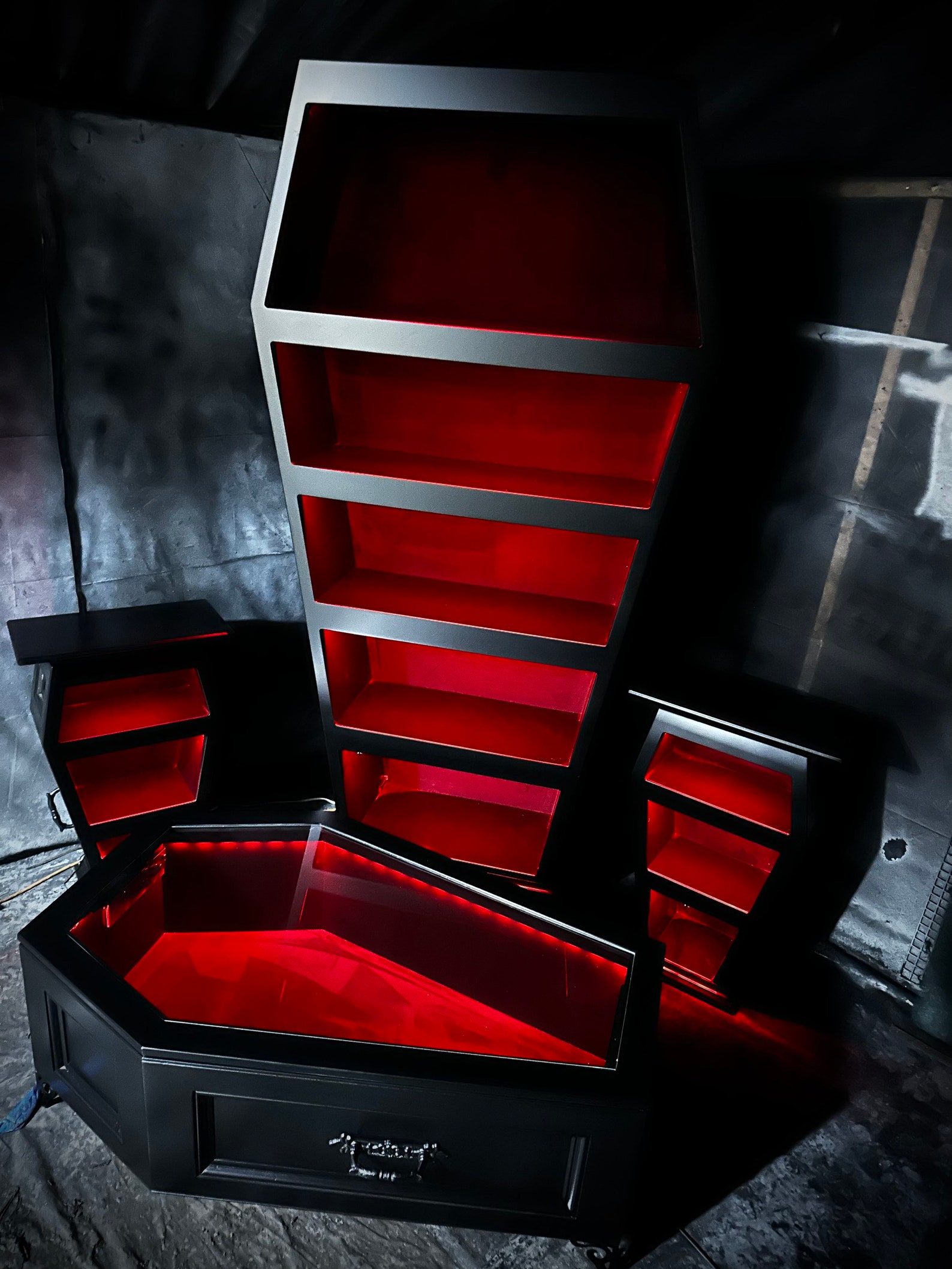 Coffin-shaped gothic furniture set with red LED lighting, including a bookshelf, two side tables, and a glass-topped coffee table