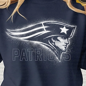May include: Navy blue sweatshirt with a white graphic of the New England Patriots logo and team name. The design has a distressed, vintage appearance. The sweatshirt is a dark colour and has a crew neck.