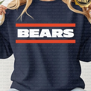 May include: Navy blue sweatshirt featuring the word "BEARS" in white block letters, framed by two horizontal orange stripes. The sweatshirt is a crew neck style and is made of a soft material.