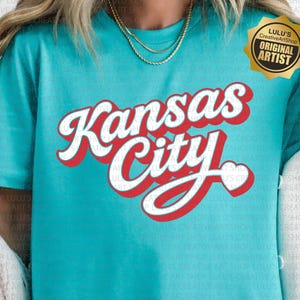 May include: A turquoise t-shirt with the words "Kansas City" in a red and white retro font. The shirt has a round neck and short sleeves. The image also includes the text "SVG/PNG" at the bottom.