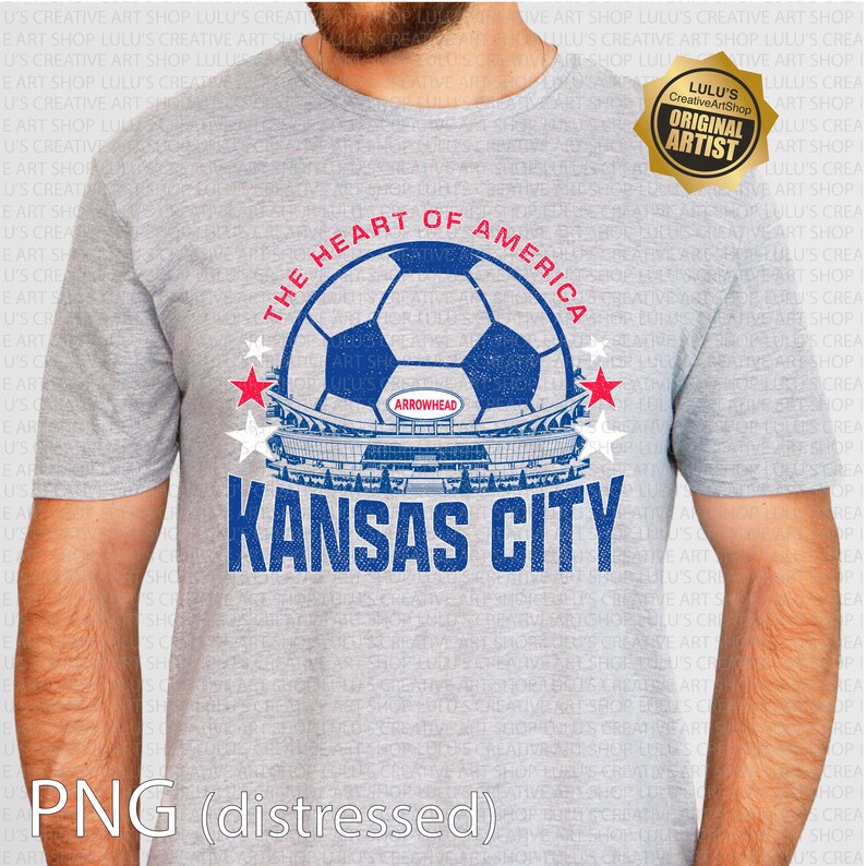 Puede incluir: Camiseta gris con un dise&ntilde;o de bal&oacute;n de f&uacute;tbol azul y blanco, el texto "THE HEART OF AMERICA" y "KANSAS CITY". El dise&ntilde;o incluye un gr&aacute;fico de estadio y estrellas rojas y blancas.