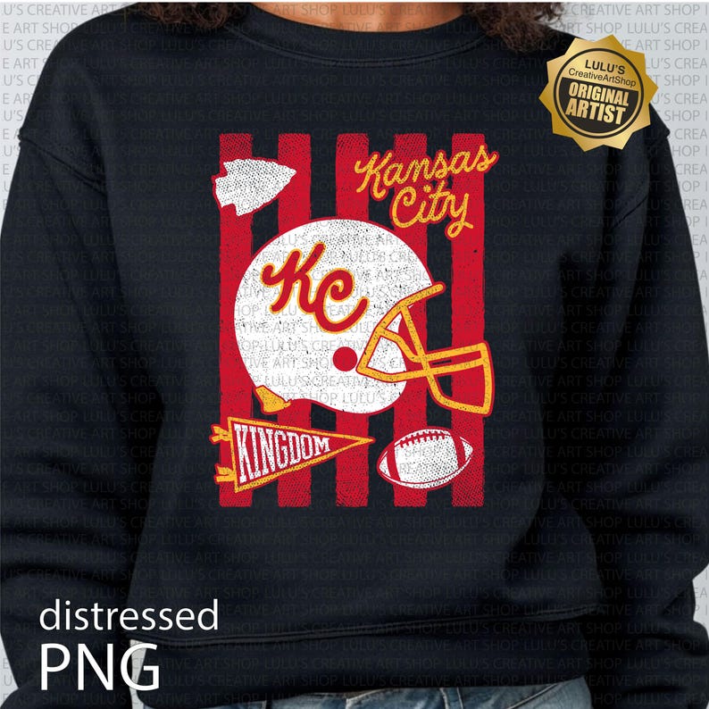 May include: A black long-sleeve sweatshirt featuring a graphic print with red vertical stripes, a white football helmet with the letters KC in red, a red pennant with the word KINGDOM, a football, and the text Kansas City in yellow script.