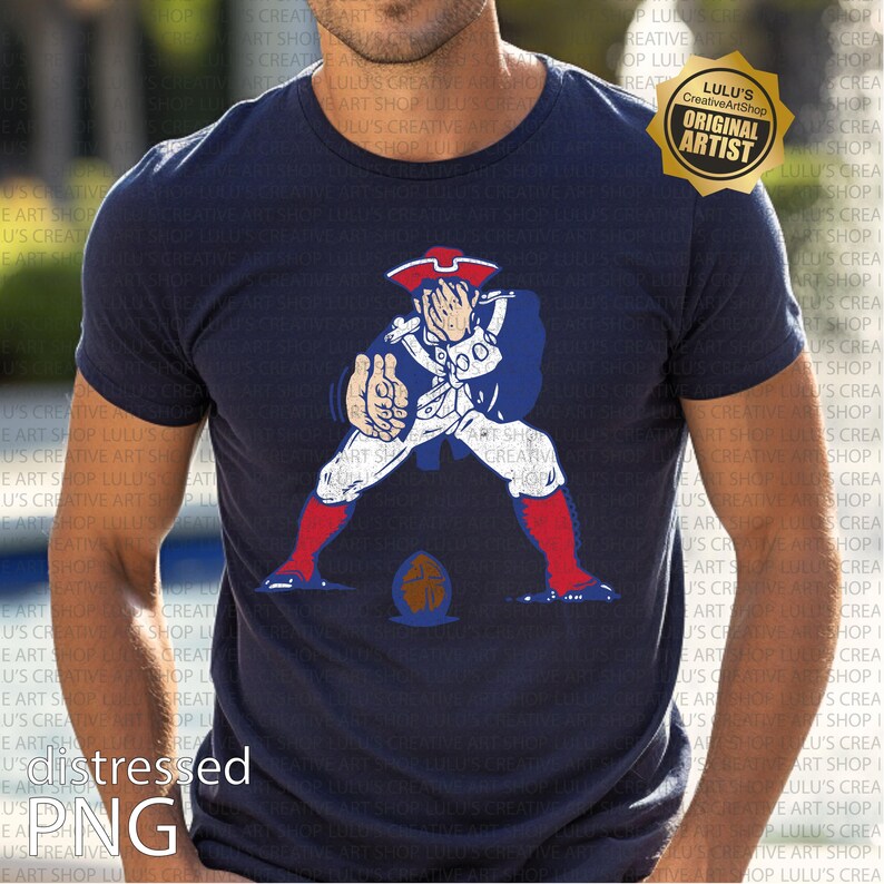 Op de afbeelding: Marineblauw t-shirt met een cartoon illustratie van een koloniale soldaat in witte en blauwe kleding, met rode laarzen en een steek. De soldaat poseert met een voetbal. Het shirt heeft een distressed PNG graphic.