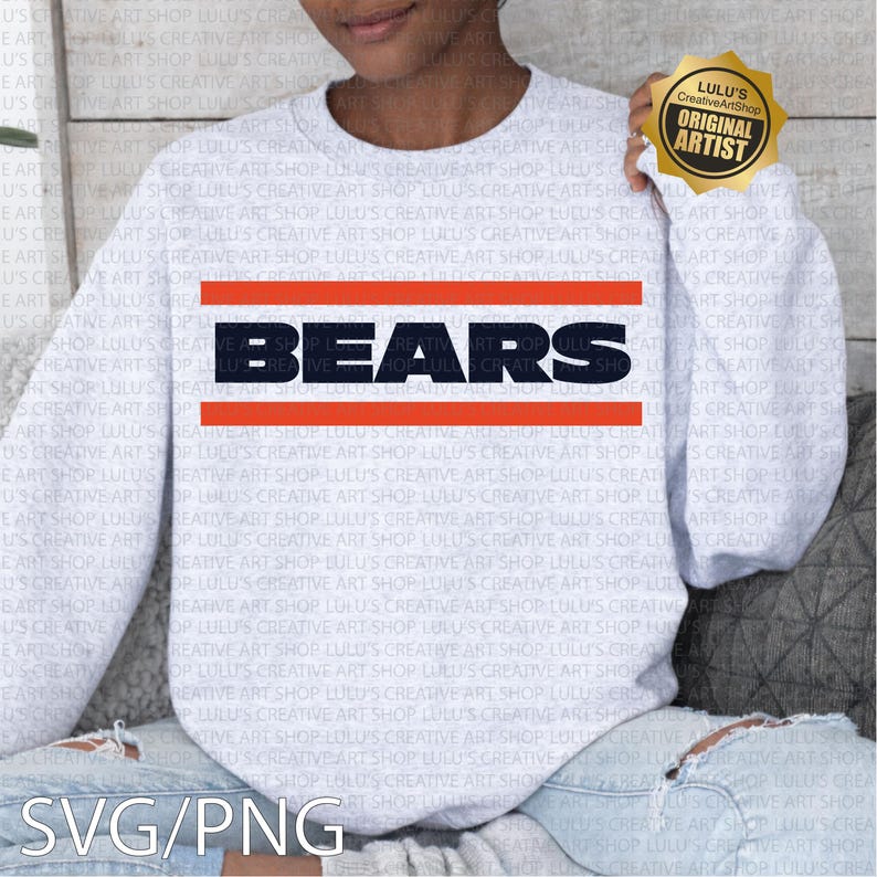 May include: A light gray sweatshirt with the word "BEARS" in navy blue block letters, outlined by orange stripes. The sweatshirt has long sleeves and is a casual style. A gold sticker with "Original Artist" is on the sleeve.
