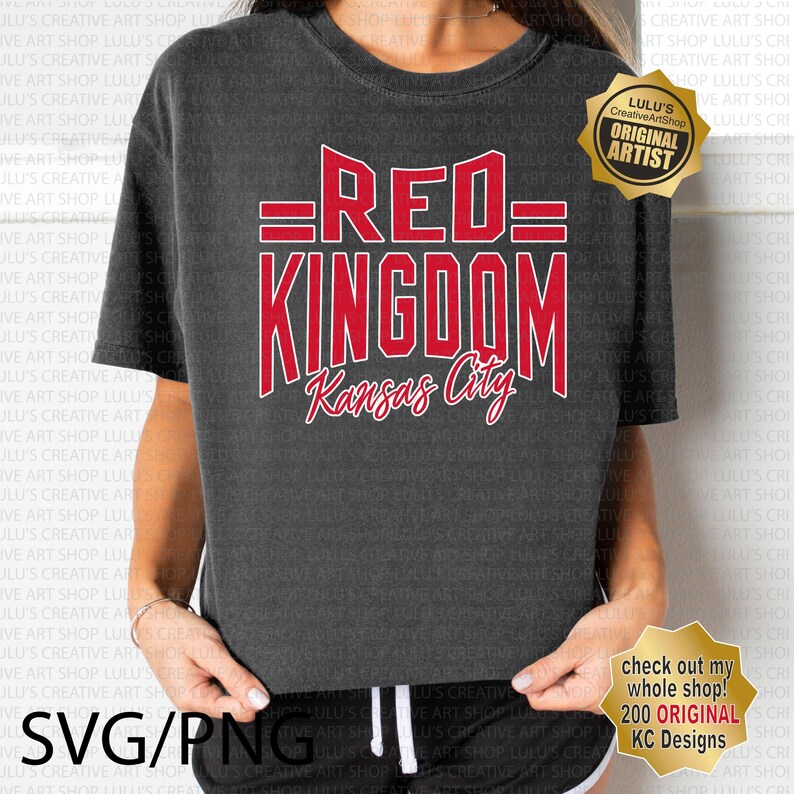 May include: A dark grey t-shirt with a red graphic design that says "=RED= KINGDOM Kansas City". The graphic is in a vintage style font. The t-shirt is being worn by a person.