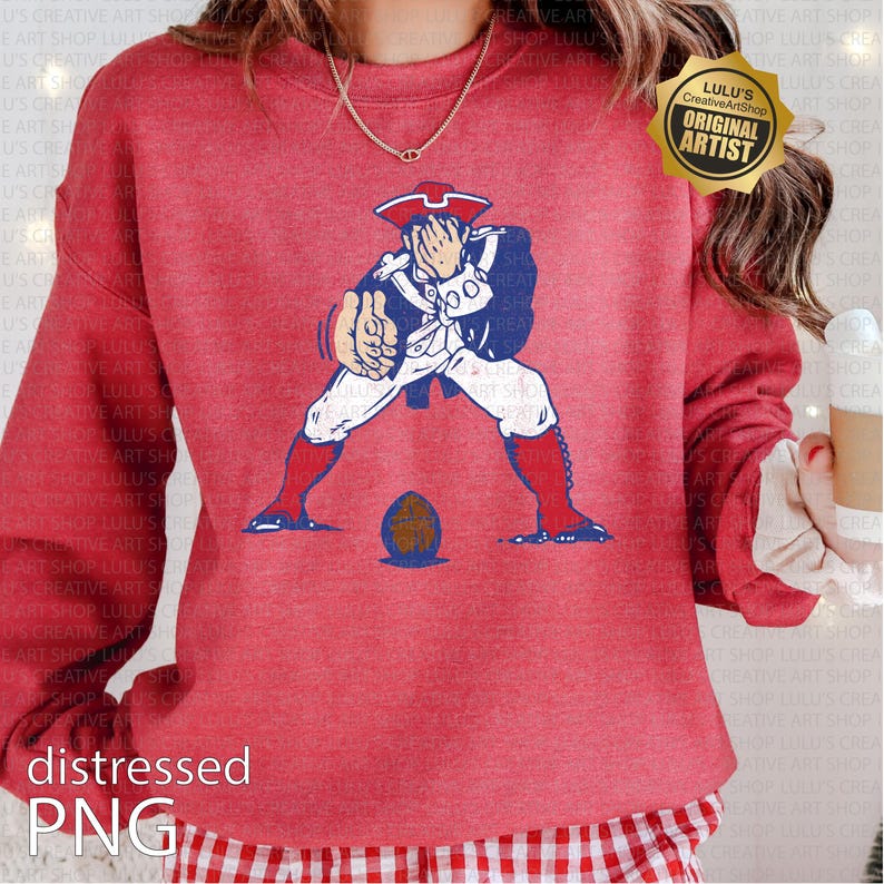 Op de afbeelding: Rode sweatshirt met een verweerde afbeelding van een koloniale soldaat in blauw, wit en rood, met een voetbal. De tekst "distressed PNG" staat onderaan. Een gouden zegel luidt "Lulu's Creative ArtShop ORIGINAL ARTIST".