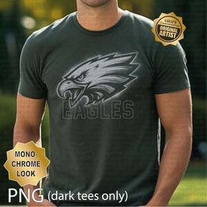 May include: Dark green t-shirt with a monochrome eagle head graphic and the word "EAGLES" underneath. The shirt has a crew neck and short sleeves. The image also includes the text "PNG (dark tees only)" and a gold seal that says "Lulu's CreativeArtShop ORIGINAL ARTIST".