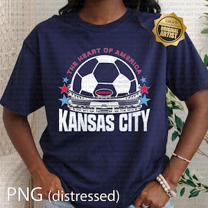 Puede incluir: Camiseta azul marino con un dise&ntilde;o de bal&oacute;n de f&uacute;tbol, el texto "THE HEART OF AMERICA" y "KANSAS CITY". El dise&ntilde;o incluye estrellas rojas y azules y una imagen de un estadio. Efecto PNG desgastado.