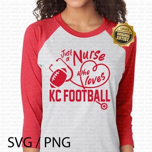 K&ouml;nnte beinhalten: Rot-wei&szlig;es Raglan-Shirt mit dem roten Text "Just a Nurse who loves KC FOOTBALL". Das Design umfasst einen Football, ein Stethoskop und ein Herz.