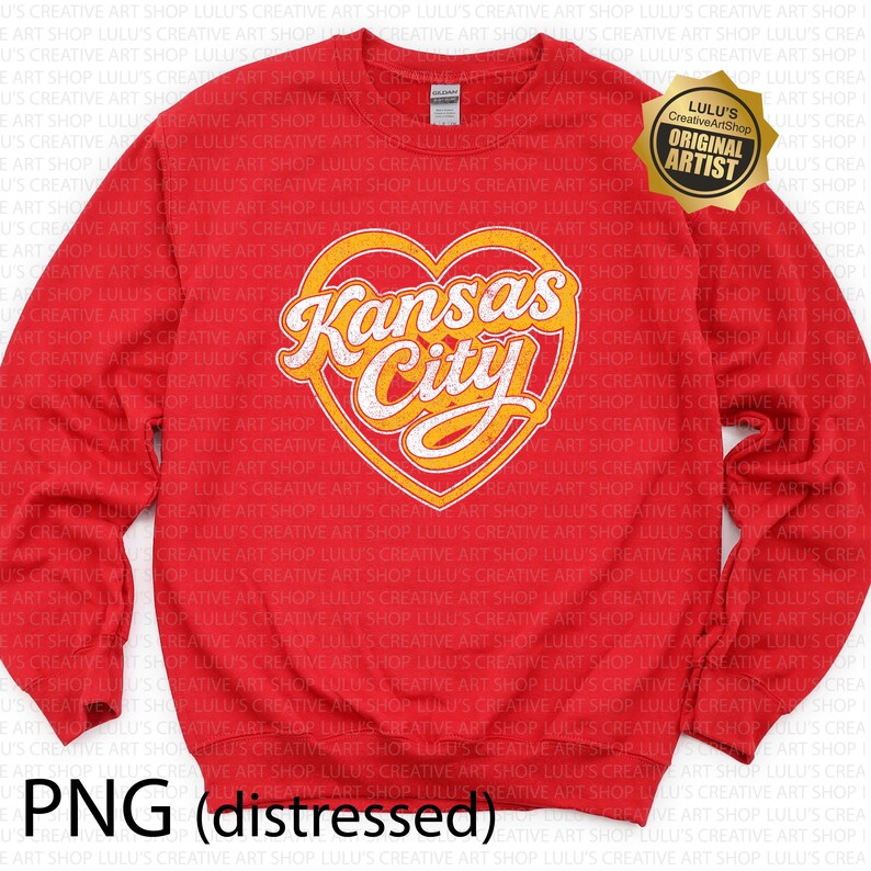 May include: Red crewneck sweatshirt featuring a heart-shaped design with "Kansas City" in a stylized font. The design is in yellow and white. The sweatshirt also has a "Lulu's Creative Art Shop" logo.