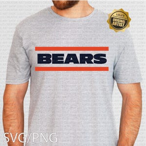 May include: Gray t-shirt featuring the word "BEARS" in navy blue, with two orange horizontal stripes. The shirt is a short-sleeved crew neck. The image also includes a gold "Original Artist" seal.