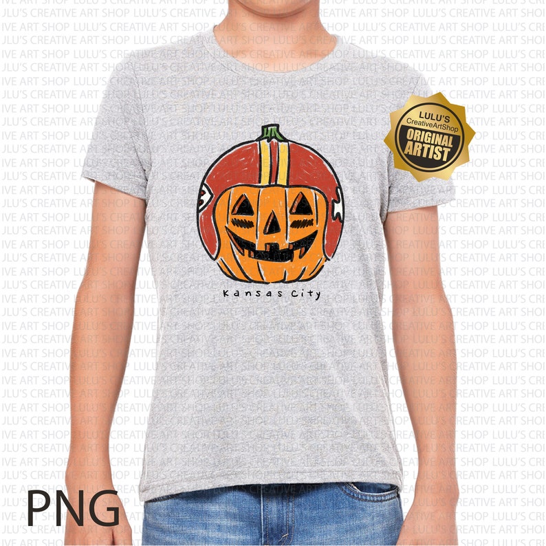 May include: A gray t-shirt featuring a cartoon pumpkin wearing a football helmet with the text "Kansas City" below. The pumpkin has a carved face. Includes a gold "Original Artist" sticker.