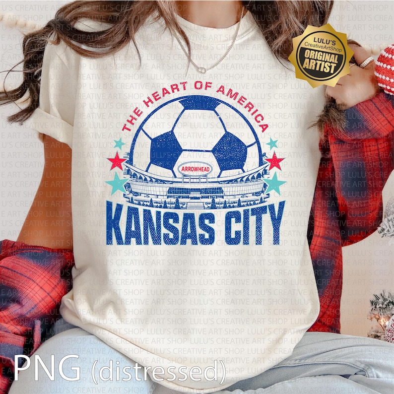 Puede incluir: Camiseta color crema con un dise&ntilde;o gr&aacute;fico desgastado. El dise&ntilde;o incluye un bal&oacute;n de f&uacute;tbol, un estadio y el texto "THE HEART OF AMERICA" y "KANSAS CITY". La camiseta tambi&eacute;n tiene el texto "ARROWHEAD".