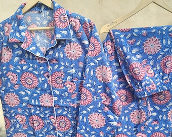 May include: A blue and pink floral print pyjama set with a button-up top and matching trousers.