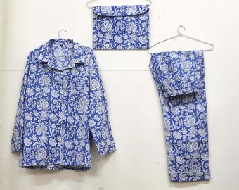 May include: A blue and white floral print pajama set with a long-sleeved shirt and pants. The set is hanging on hangers.