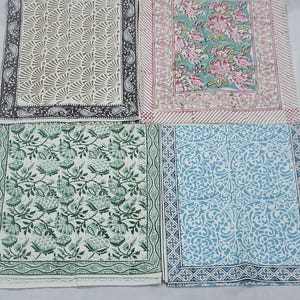 Può includere: Quattro tovagliette all'americana in tessuto con diversi motivi. Le tovagliette sono tutte quadrate e hanno uno sfondo bianco. I motivi includono un design geometrico, un design floreale, un design paisley e un design a foglia.