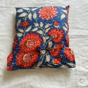 May include: A blue and orange floral patterned pillow with a white button closure.