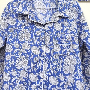 May include: A blue and white floral print pajama top with a button-up front and a white trim.