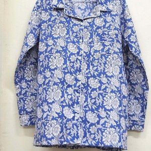 May include: A blue and white floral print long-sleeved shirt with a button-up front and a white trim.